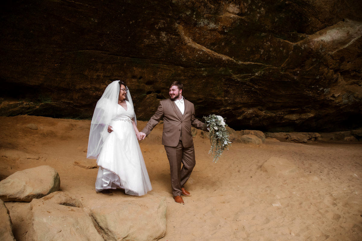 Sarah and Gabe wanted a simple, wedding in nature, so they eloped in Ohio's beautiful Hocking Hills. The rainy spring day made it even more romantic as they said their vows under Ash Cave's huge overhang, the light rain a perfect soundtrack. They then visited Conkles Hollow, where the misty cliffs and green spring growth created a magical scene. Despite the rain, they were so happy, and their elopement was exactly what they dreamed of: a loving celebration in the stunning Hocking Hills.