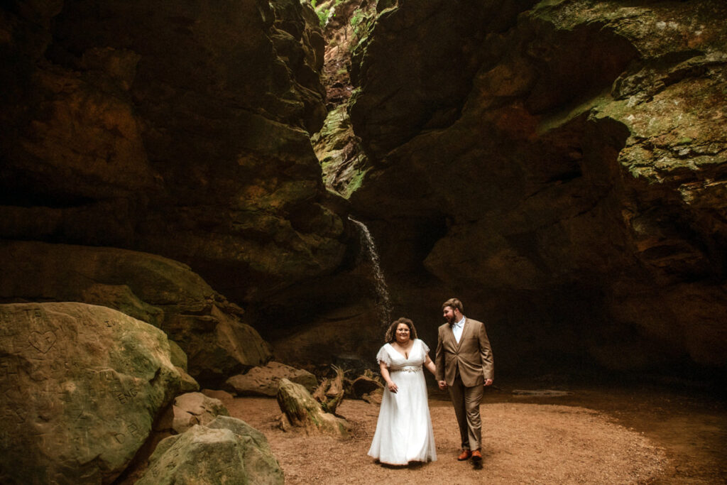 Sarah and Gabe wanted a simple, wedding in nature, so they eloped in Ohio's beautiful Hocking Hills. The rainy spring day made it even more romantic as they said their vows under Ash Cave's huge overhang, the light rain a perfect soundtrack. They then visited Conkles Hollow, where the misty cliffs and green spring growth created a magical scene. Despite the rain, they were so happy, and their elopement was exactly what they dreamed of: a loving celebration in the stunning Hocking Hills.