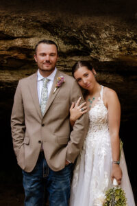 Elopement couple smiling at the camera in front of Upper Falls at Old Man’s Cave in Hocking Hills.