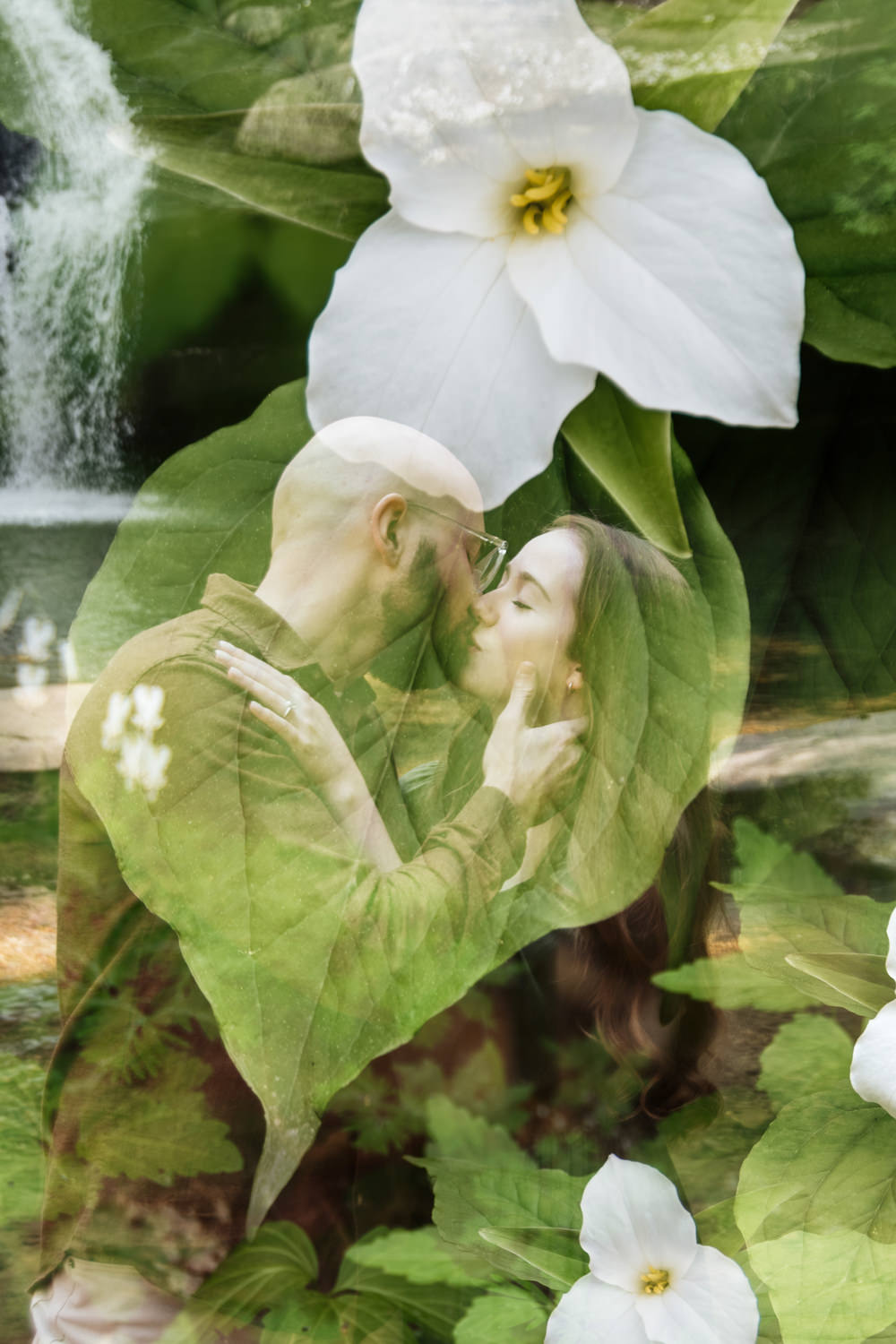 A double exposure portrait of an engaged couple layered with delicate spring ephemeral wildflowers. The couple’s silhouettes are translucent, allowing the intricate details of the blooms and forest greenery to shimmer through them, creating a mystical, ethereal effect that blends the subjects into the natural landscape.