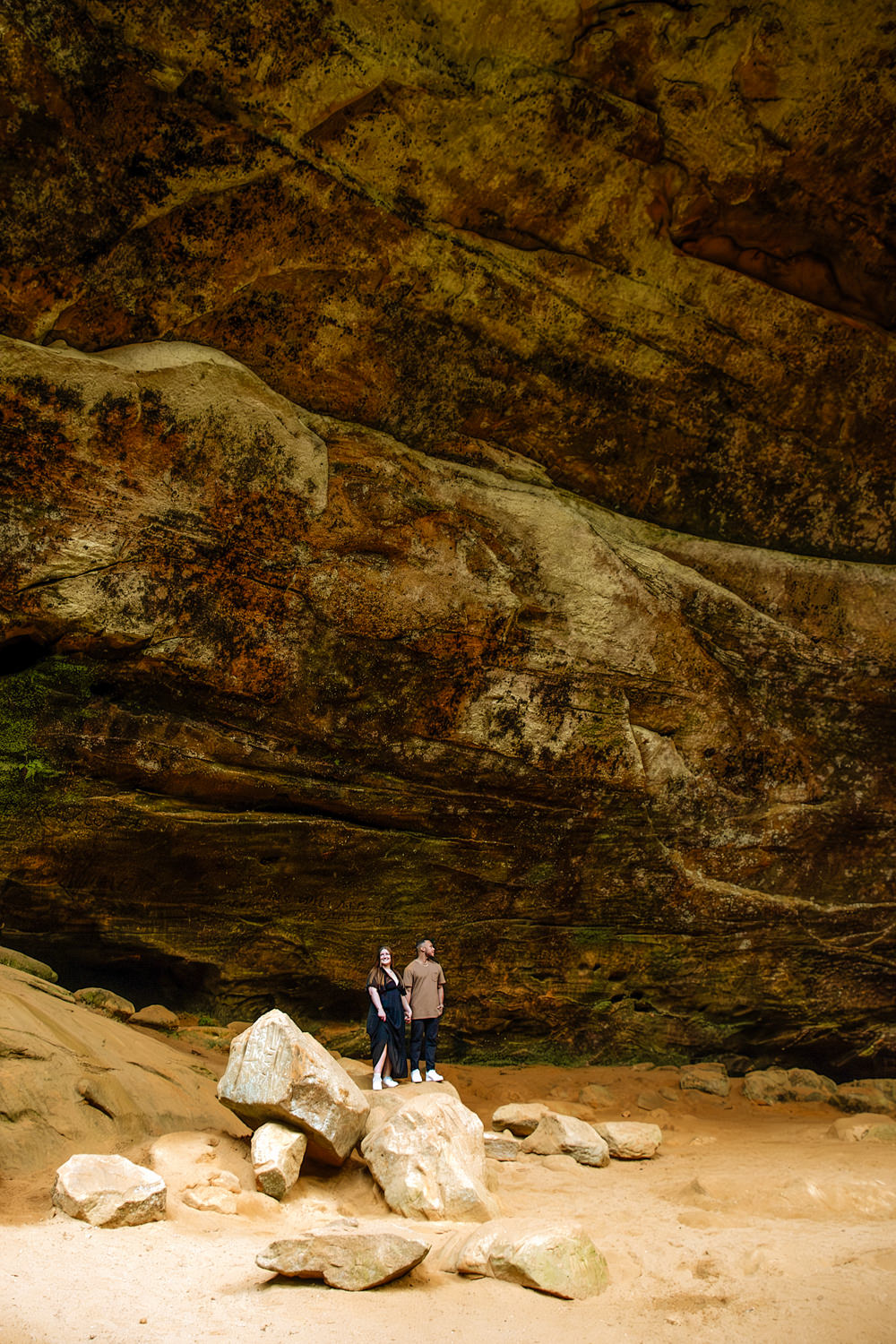 A couple looks tiny next to the epic back wall of Ash Cave.