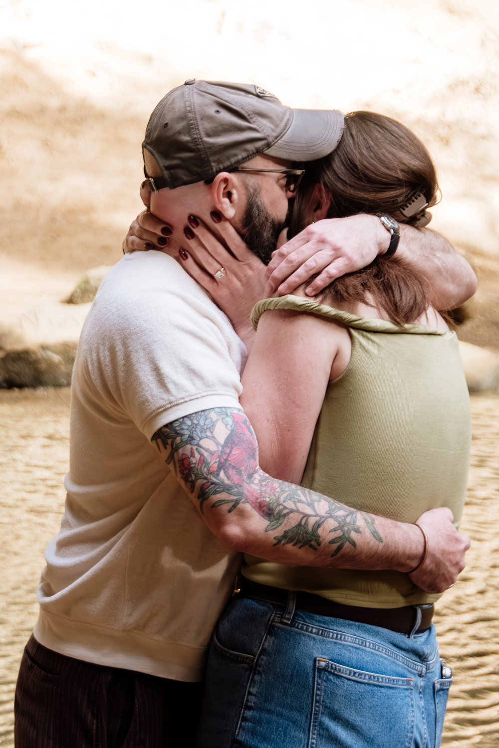 A woman and man embrace after he proposed to her in front of a waterfall in the Hocking Hills.