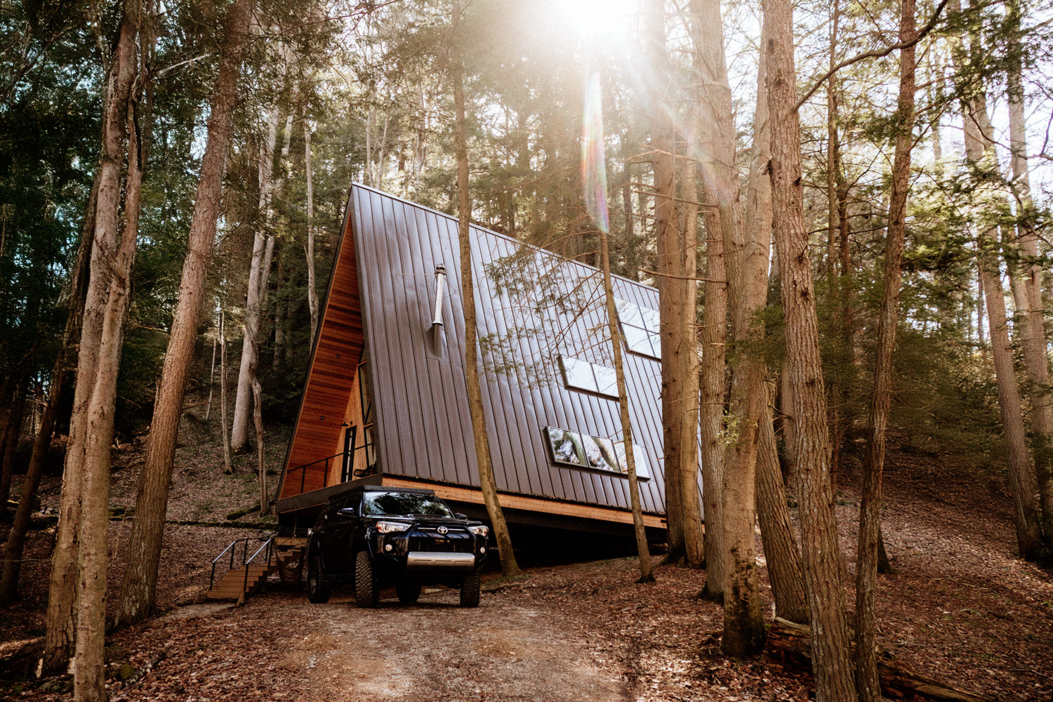 A jeep sits in front of Dunlap Hollow A-Frame Airbnb cabin in the Hocking Hills.