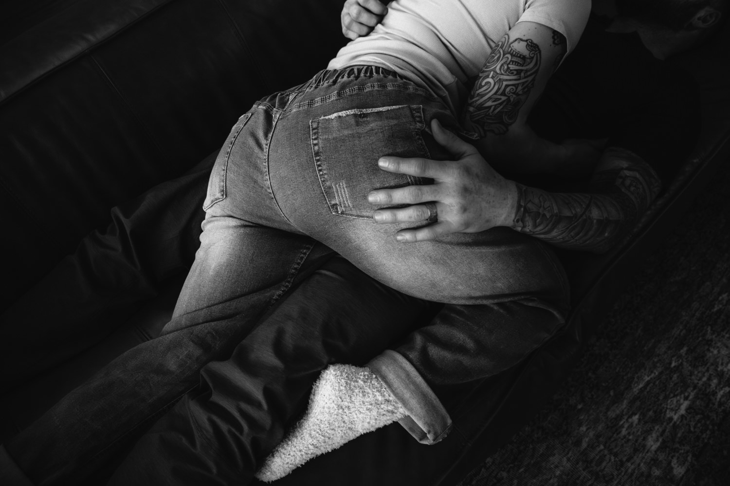 A woman lays on a man who is in turn laying on a couch at Dunlap Hollow cabin in the Hocking Hills.