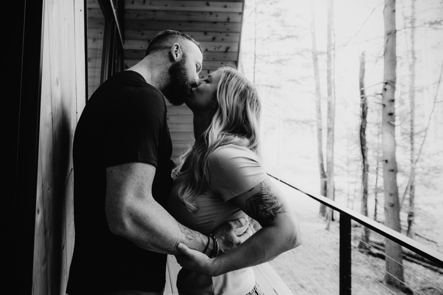A woman and man pose on the balcony of an A-frame cabin in Ohio for their anniversary portraits. They traveled from North Dakota for their photo session.