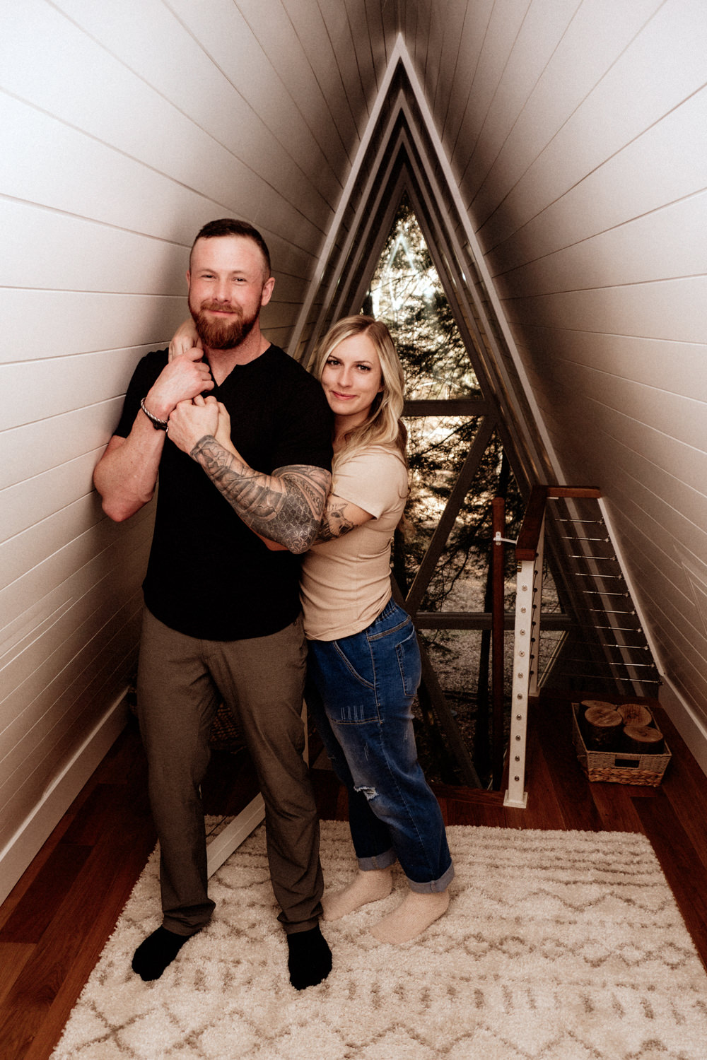 A woman wraps her arms around a man as they stand in the loft of the Dunlap Hollow A-frame cabin in the Hocking Hills.