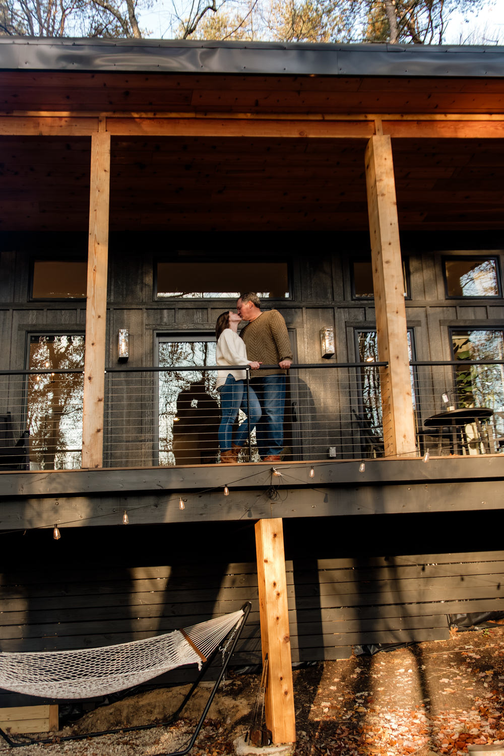 Jeff dipping Taylor playfully on the cabin’s outdoor patio, surrounded by fallen November leaves and the soft, fading golden light.