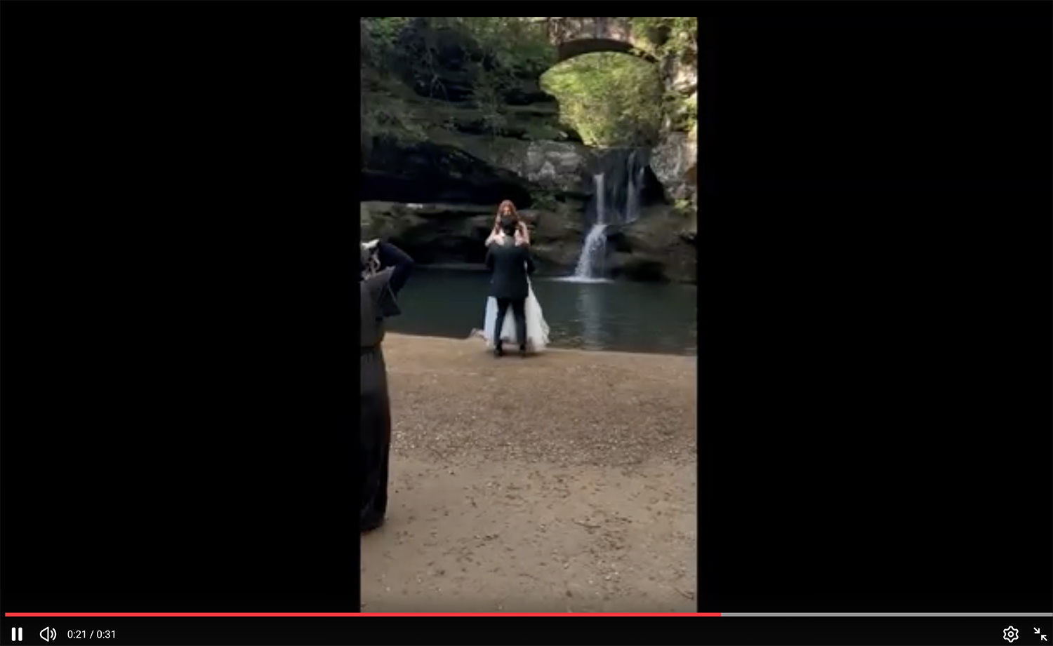 Video screenshot of Hocking Hills Elopement Photographer Elizabeth Nihiser Photography at work photographing a couple in front of Upper Falls.