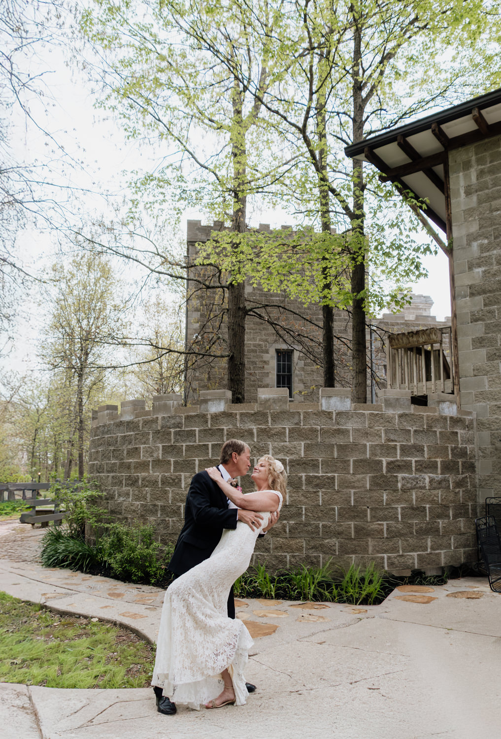 A man in his 60s dips a woman in her 60s in front of the ramparts at Ravenwood Castle in the Hocking Hills.