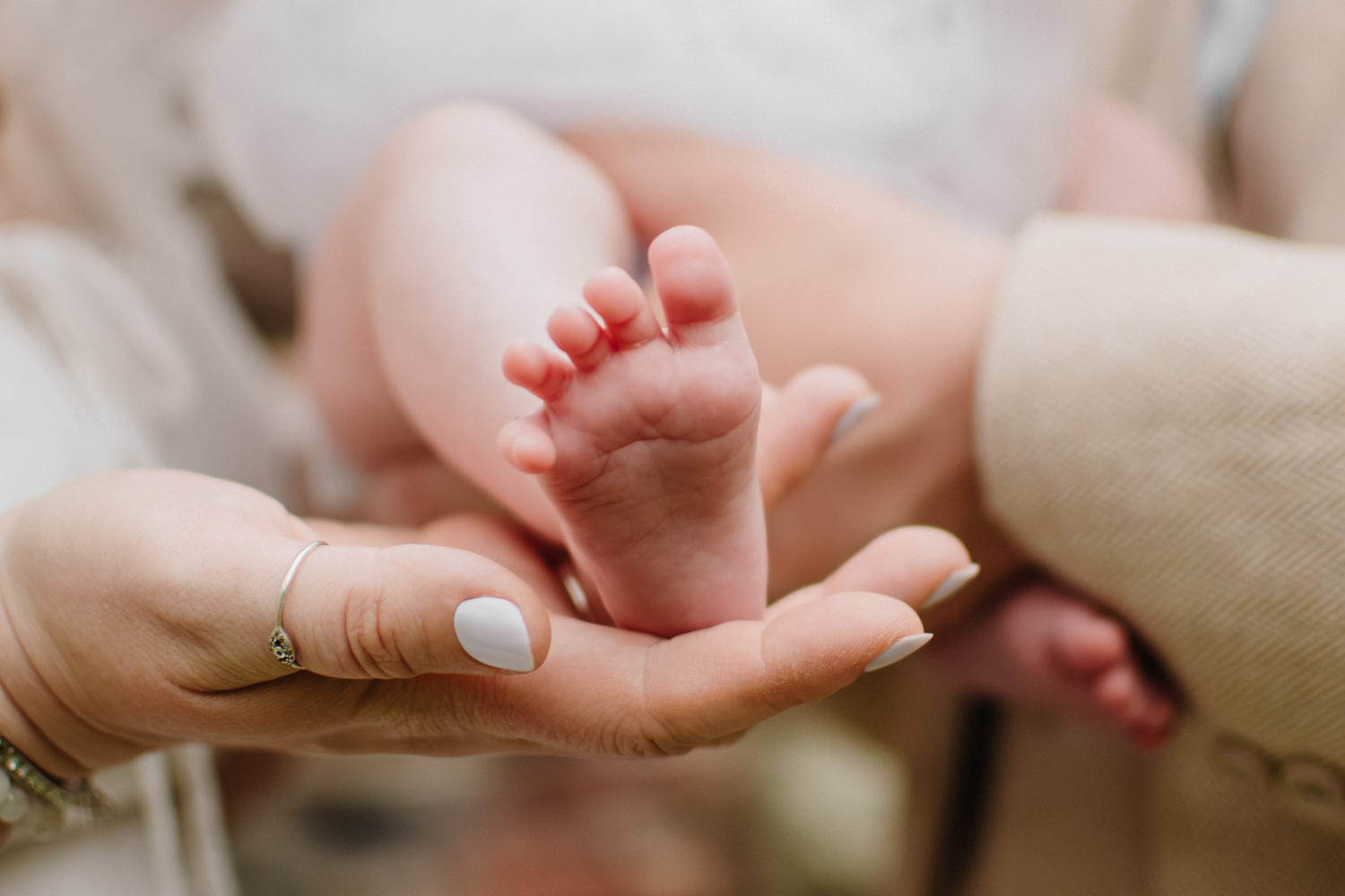 A close up photo of a baby's foot being held in her mother's hand.