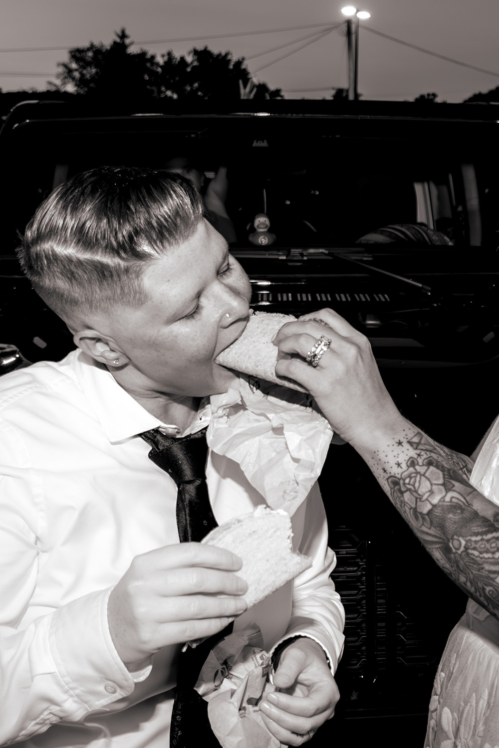 A bride feeds another bride a Taco Bell taco on their anniversary.