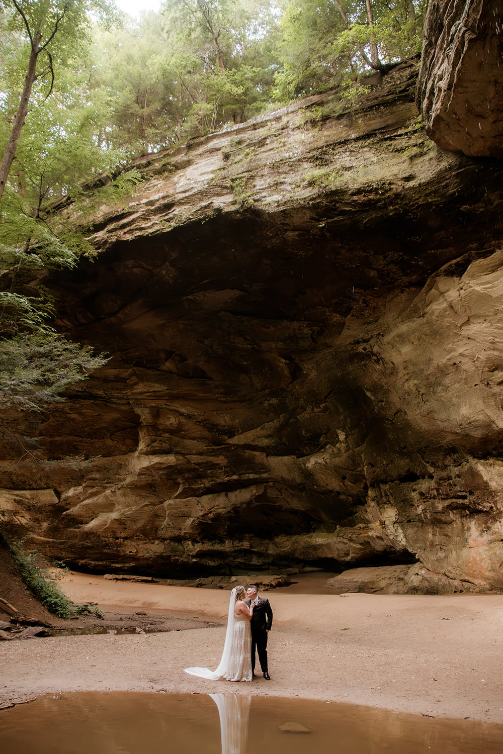 Epic wide shot of Ash Cave with a tiny couple by the water pool.