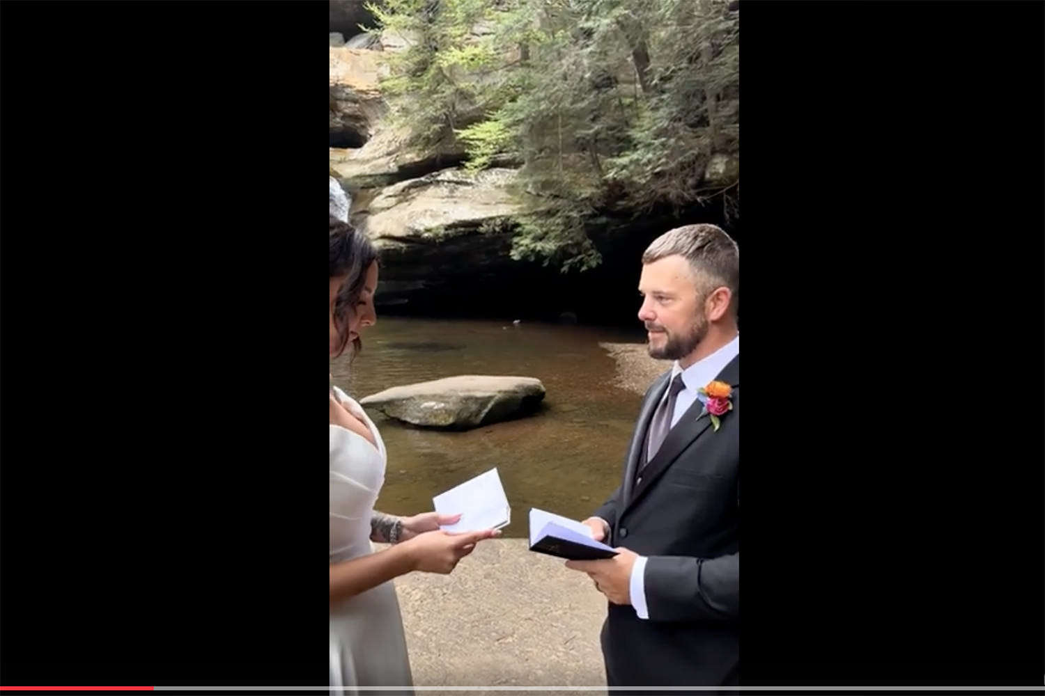 Screenshot of a man and woman reading their wedding vows in Hocking Hills when a Common Merganser flies in behind them.