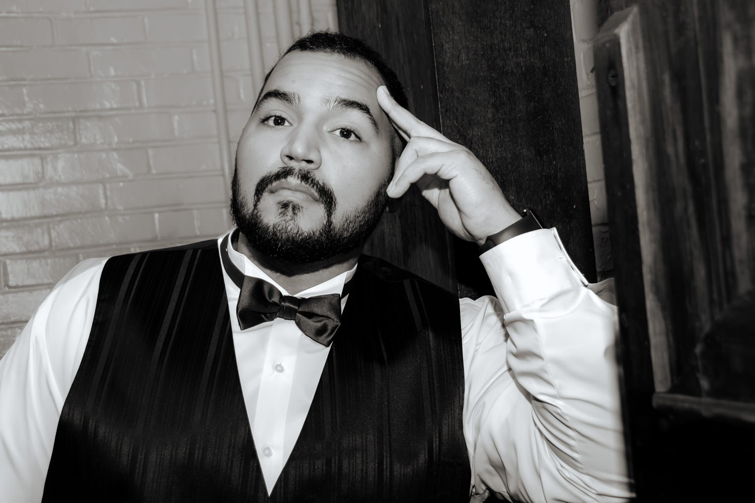 Moody black and white portrait of a groom pausing before his wedding ceremony inside a historic building at Stan Hywet Hall.
