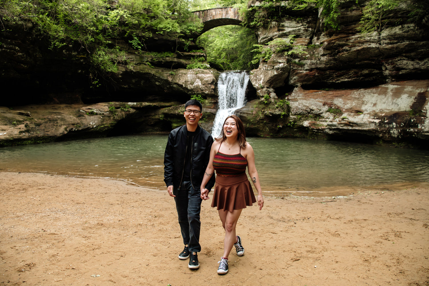An asian couple walks in front of Upper Falls at Old Man's Cave in May after a surprise proposal.