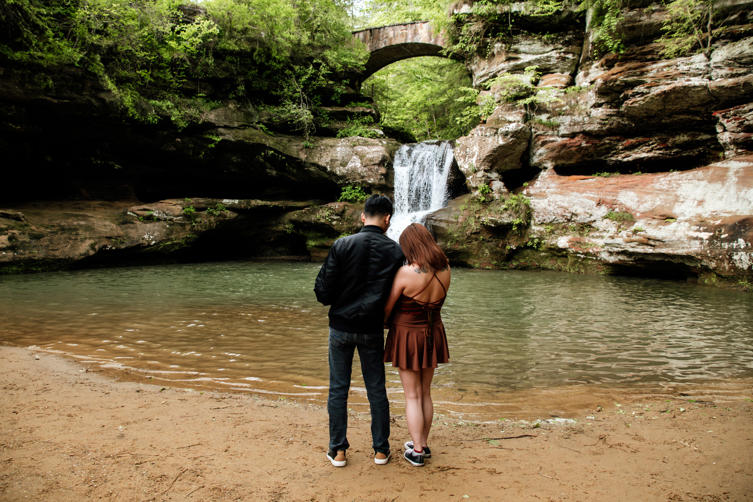 A couple looks at Upper Falls in the Hocking Hills.