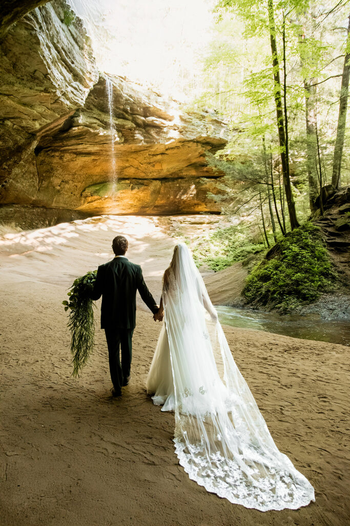 High-contrast portrait of a couple standing close in a deep green forest, their red hair and green suit perfectly complementing the natural landscape.
