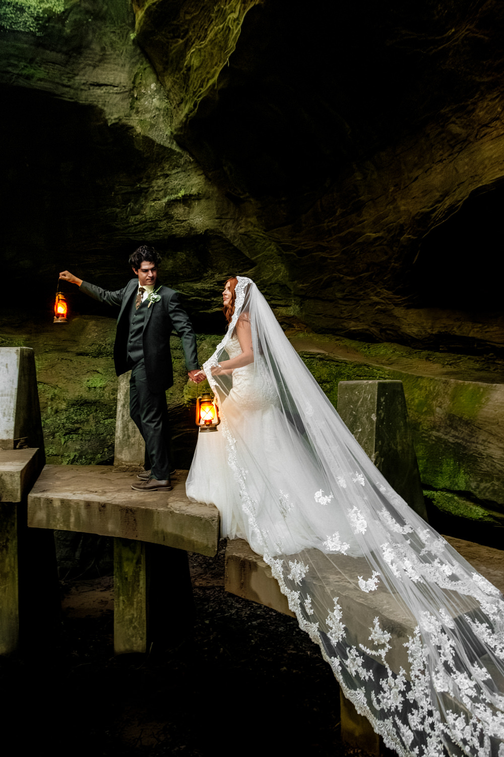 An elopement couple holds lanterns and walks across the Japanese Stepping Stone Bridge at Old Man's Cave gorge in the Hocking Hills, Ohio.