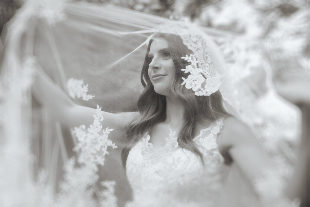 Close-up details of a bride's lace mantilla veil contrasting beautifully against dark, textured cave walls.