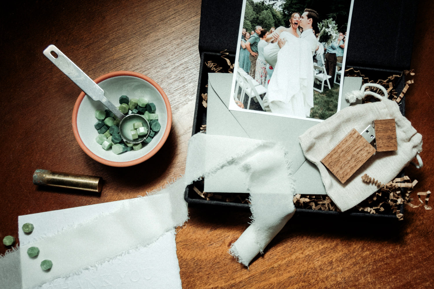 Linen wedding photo box with prints, chiffon ribbon, wood usb flash drive, hand embossed thank you card, and wax stamp are all included in wedding packages.