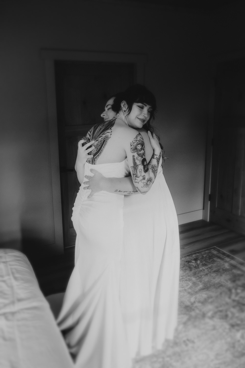 Bride and bridesmaid sharing a hug while getting ready.