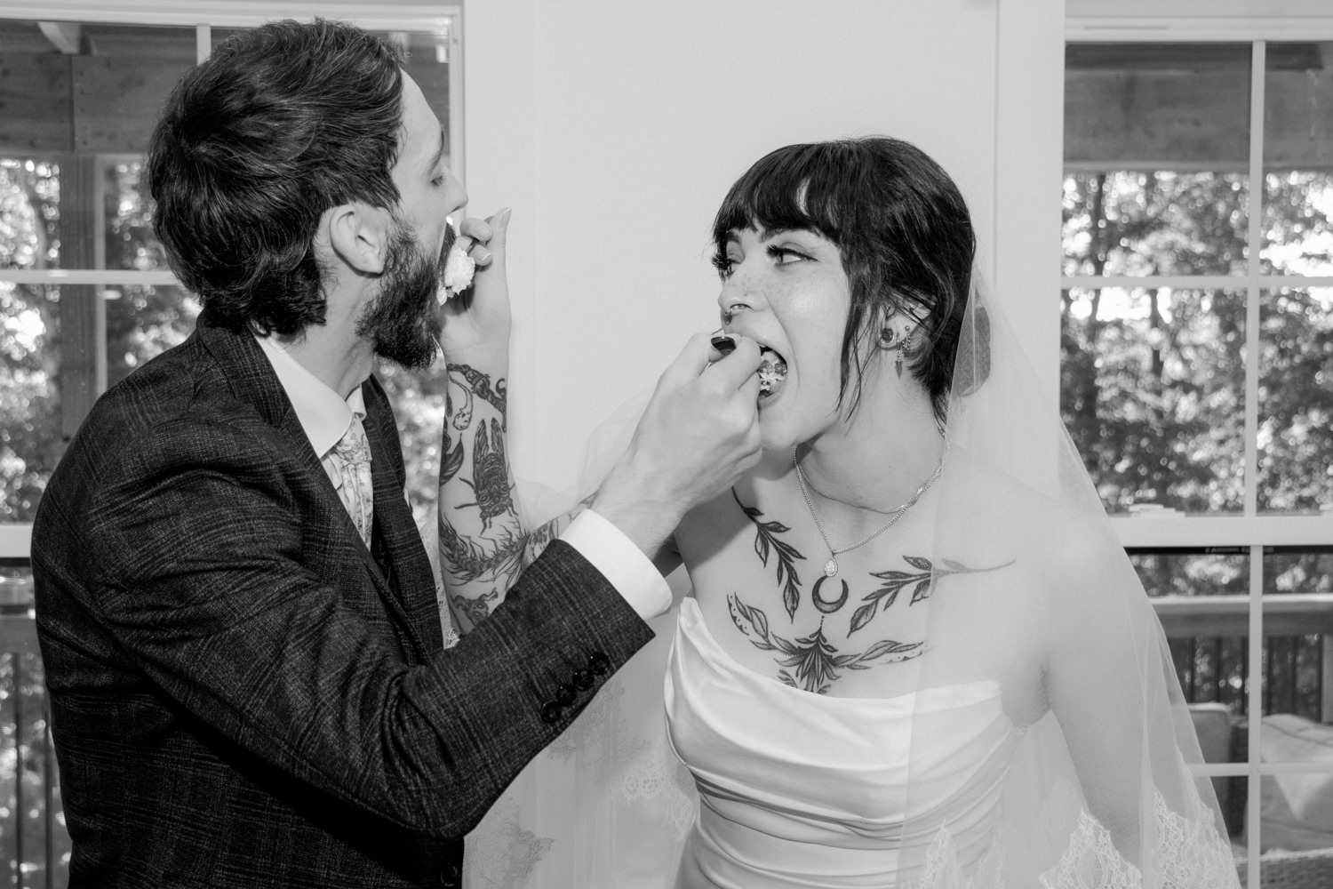 Bride and groom feeding each other a slice of wedding cake at their cabin reception.