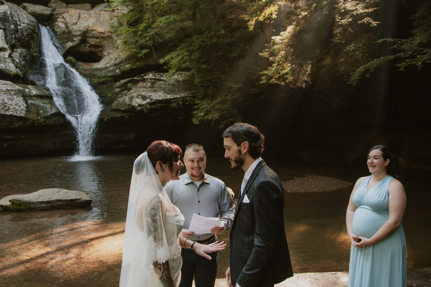 Close friend officiating a wedding ceremony for a couple in front of a towering rock face.
