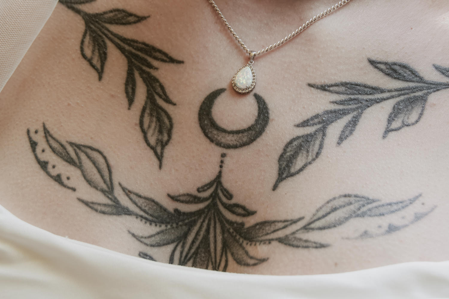 Close up of a bride's witch chest tattoos.