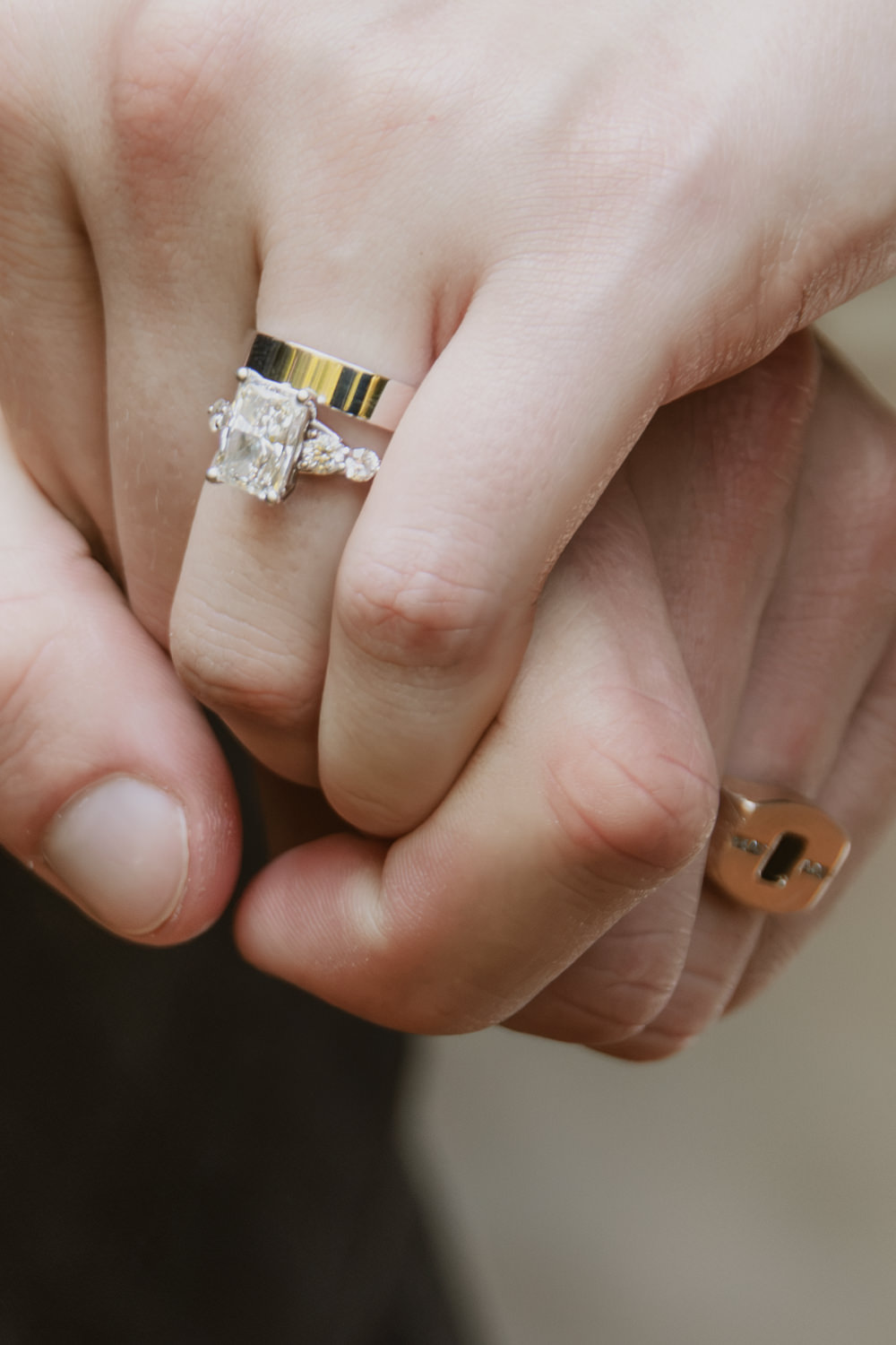 Close up of a bride and groom's hands with wedding rings.