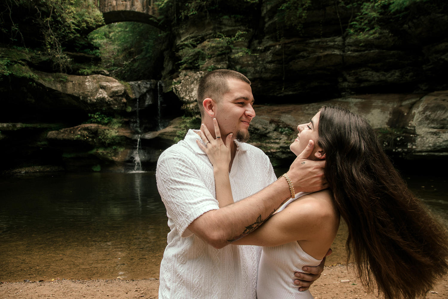 A couple twirls and moves in front of a waterfall in the Hocking Hills.