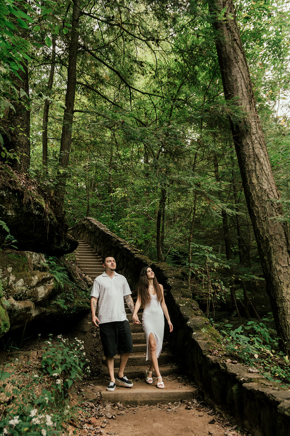 An engaged couple walks down a stone stairs at Old Man's Cave in September.