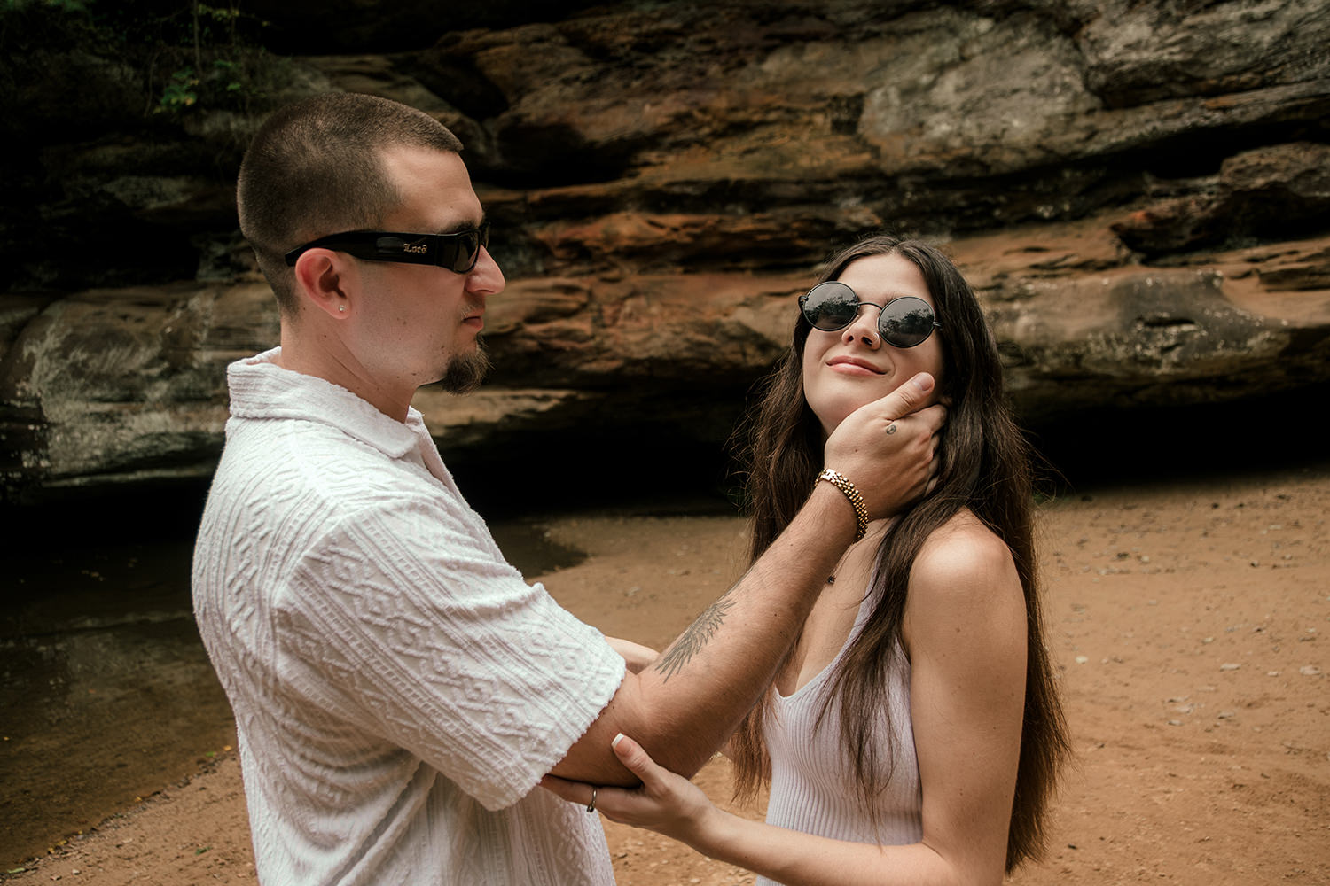 A cute engaged couple wears trendy sunglasses during their engagement session in the Hocking Hills.