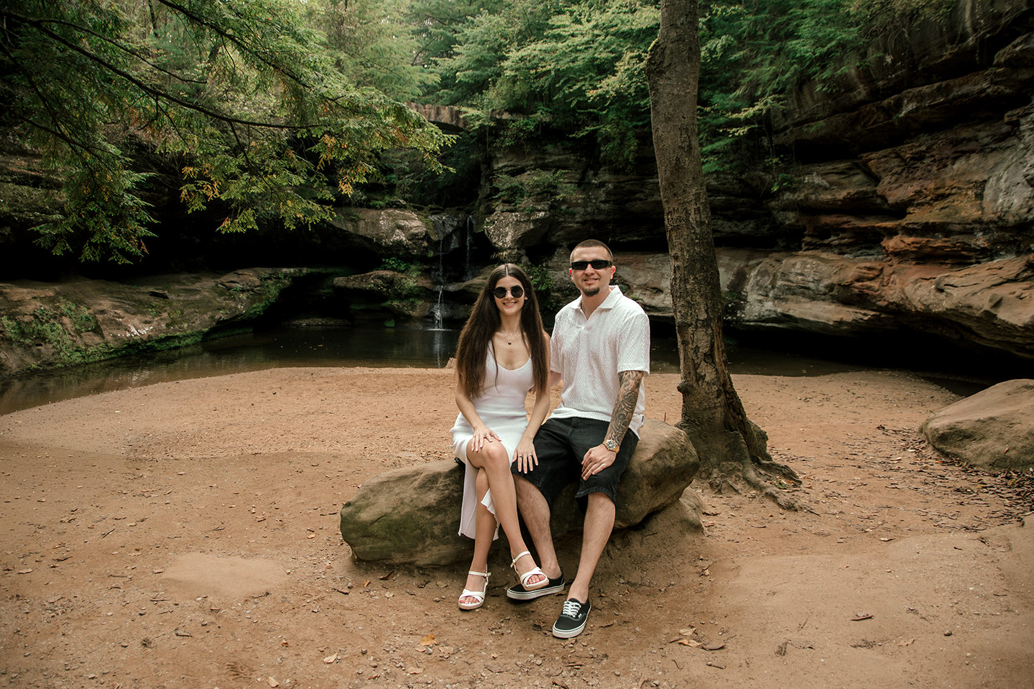 Alethia and Anthony sitting together on a rock along the gorge trail.