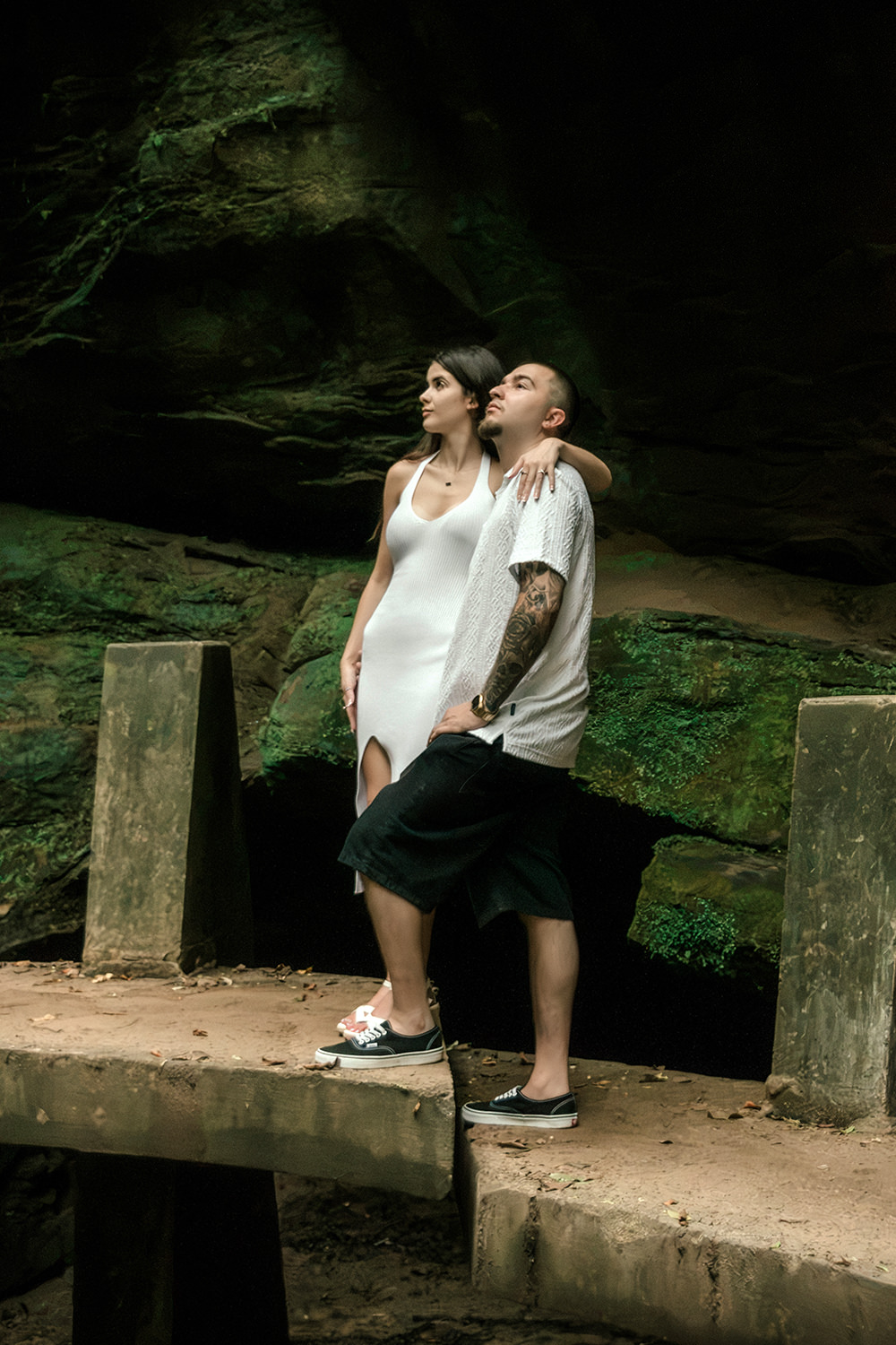 Close-up of Alethia smiling while leaning against Anthony's shoulder on a stone hiking trail.