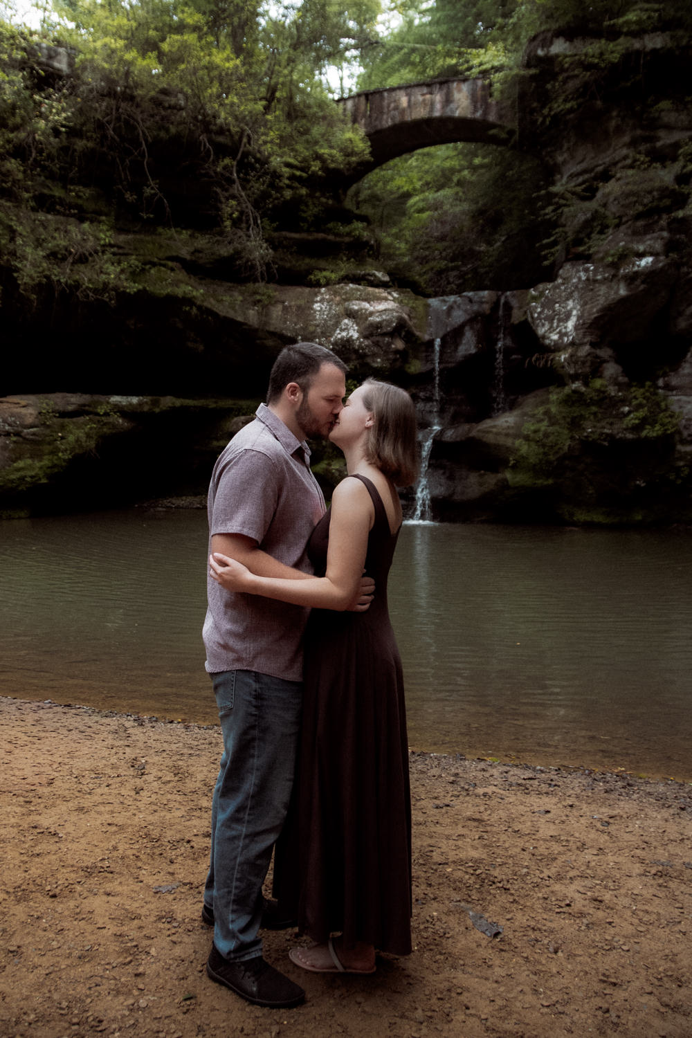 Profile shot of Mary Catherine and Jordan kissing softly in front of Upper Falls.