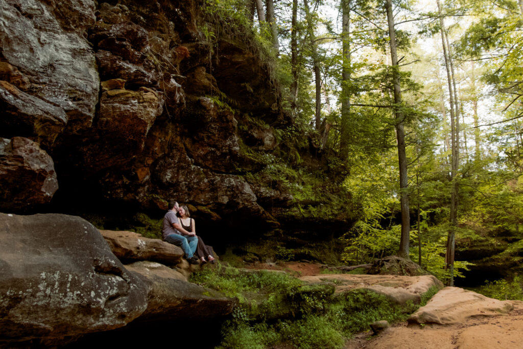 Close-up of a married couple smiling and embracing near the mossy sandstone cliffs at Upper Falls during their 10th anniversary session.