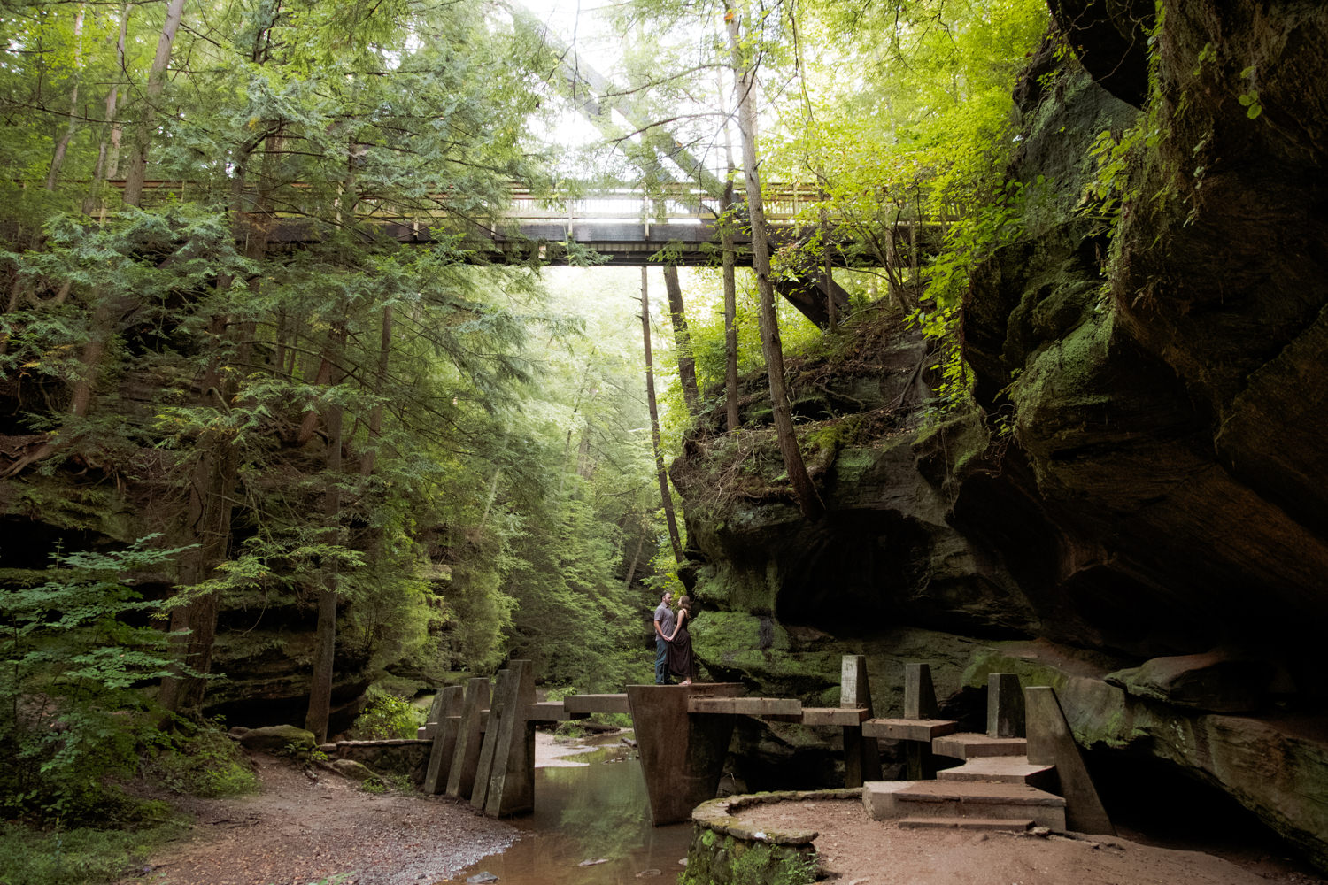 Couple walking together over the Japanese Stepping Stone Bridge in Old Man's Cave Gorge.