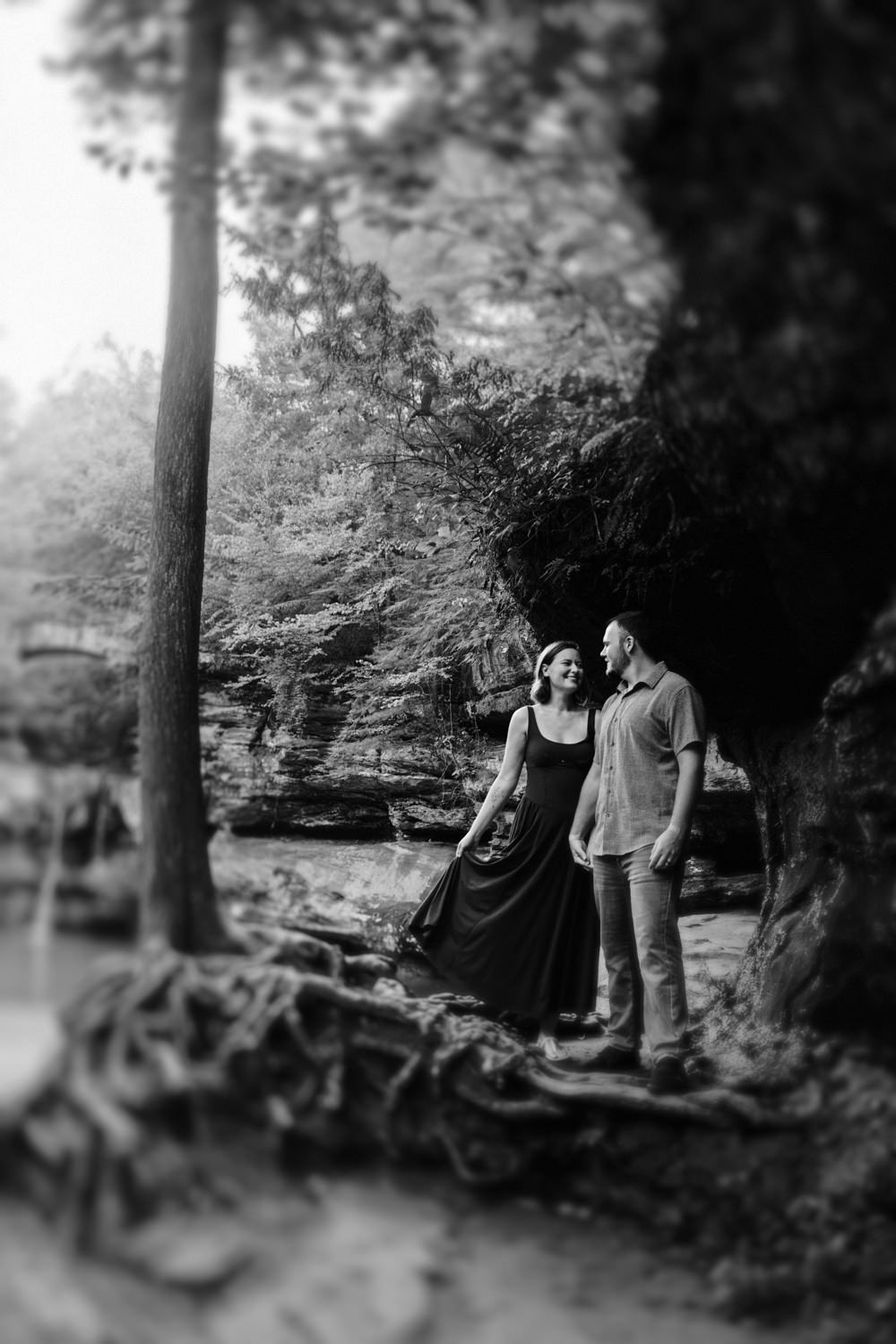 Full-length shot of a couple standing near the edge of a waterfall in Hocking Hills.