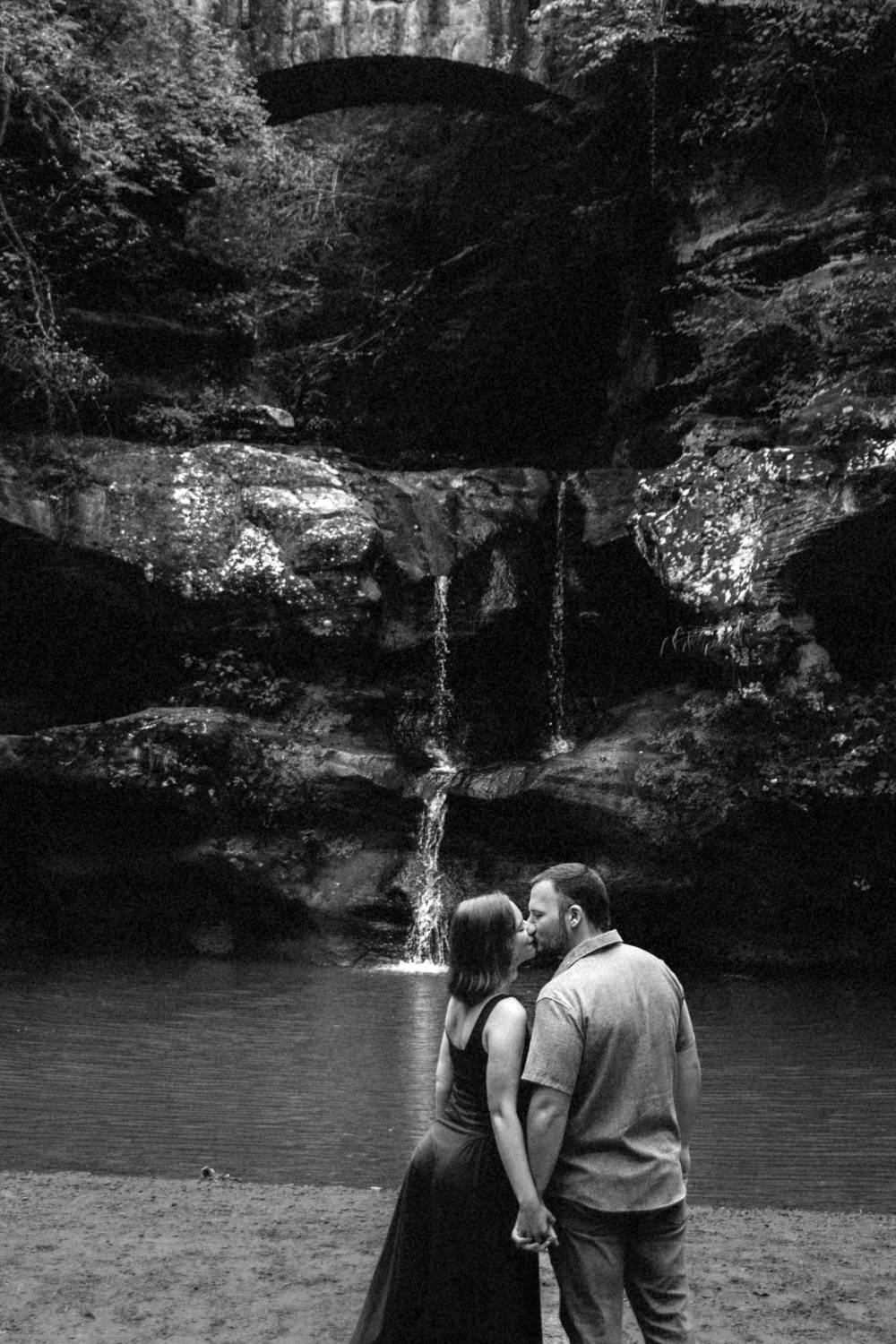 Black and white of Upper Falls cascading over rock formations into a calm pool in Hocking Hills State Park.